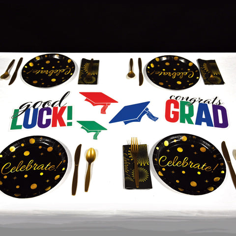Multicolor Congrats Grad plastic cutouts displayed with Graduation-themed tableware set  on a white background.
