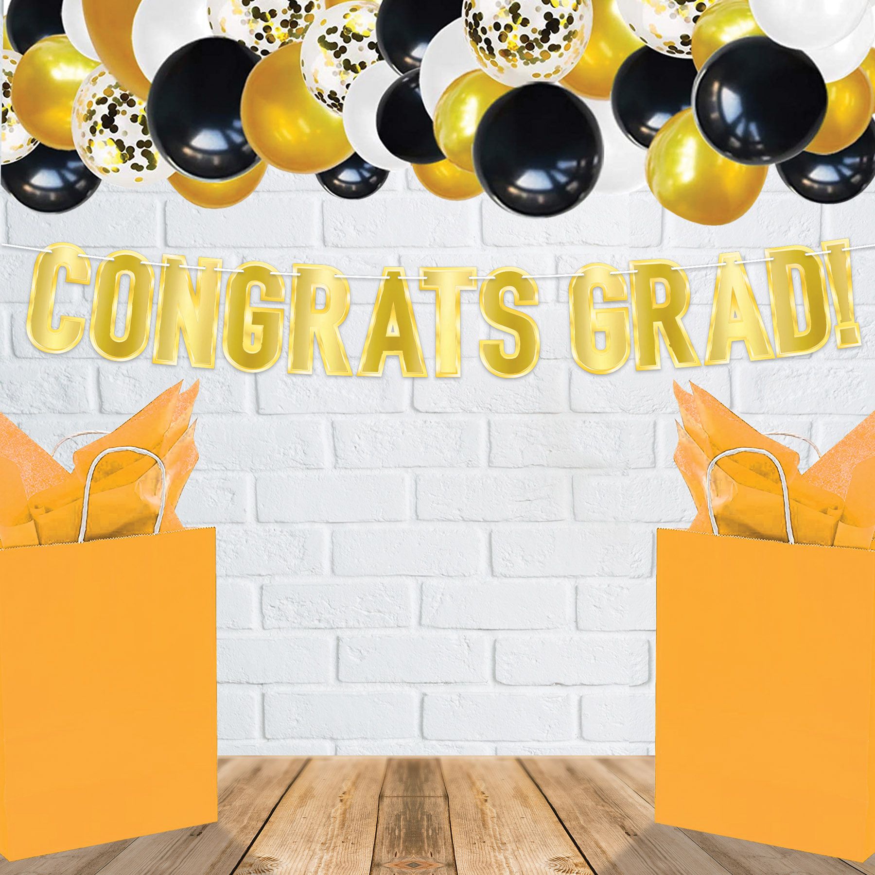 Gold foil Congrats Grad banner with shiny metallic lettering graduation party decoration shown on a wall  as part of decor