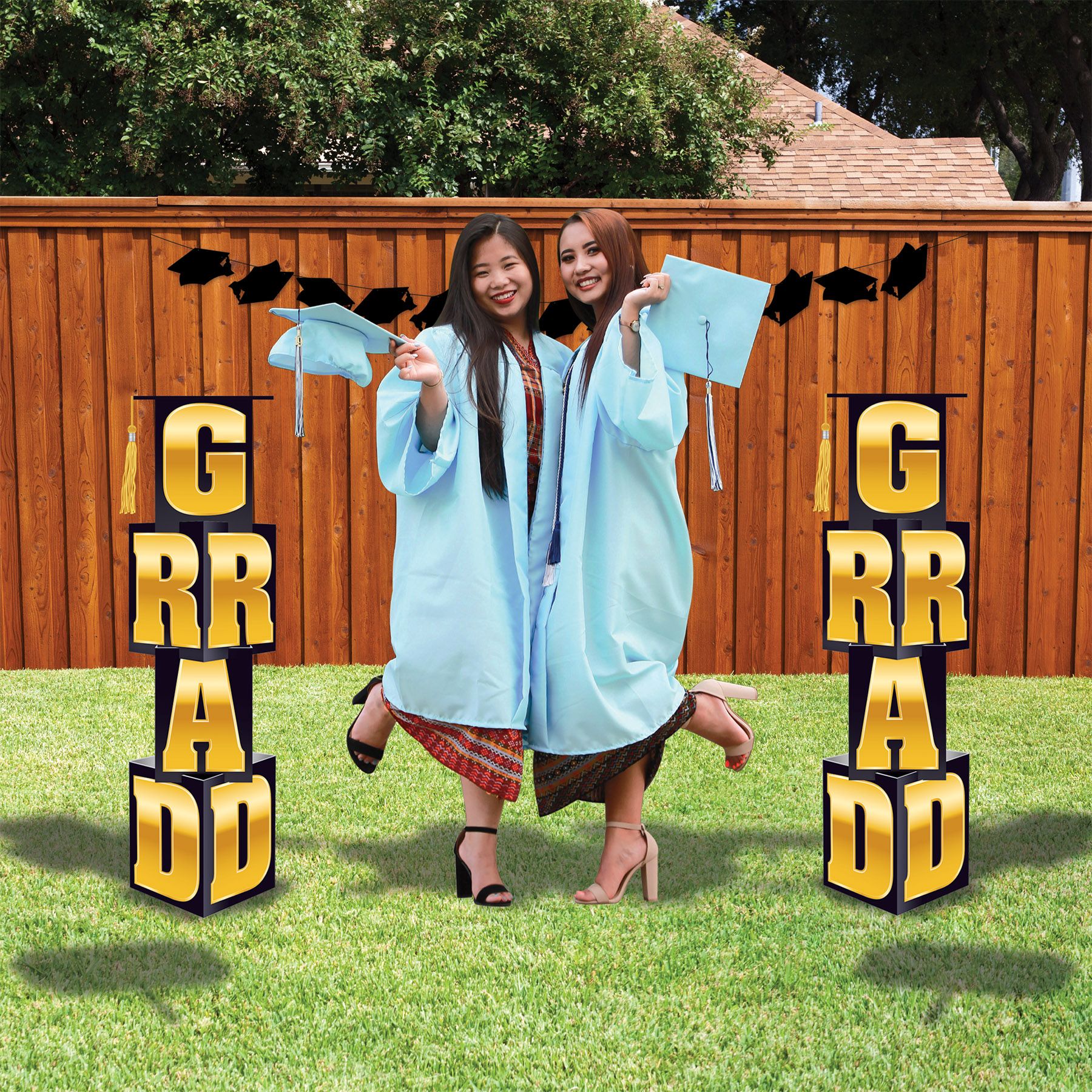Graduation GRAD column decoration showing stacked letters and tassel top photo prop display with two recent graduates. 